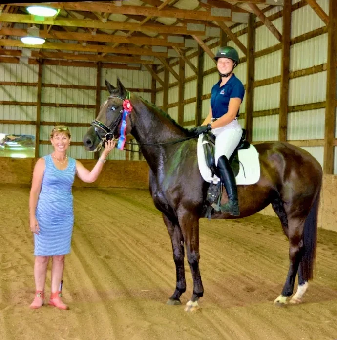 Ingrid's Solid Dancer with rider and handler in indoor arena